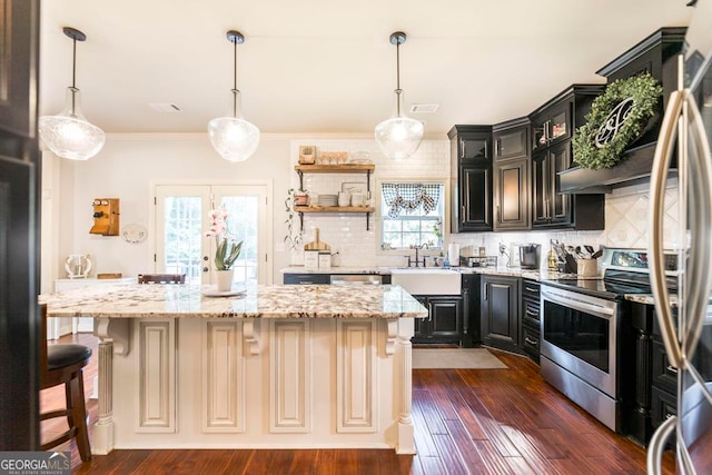 kitchen featuring backsplash, a kitchen island, light stone countertops, dark wood-type flooring, and stainless steel appliances