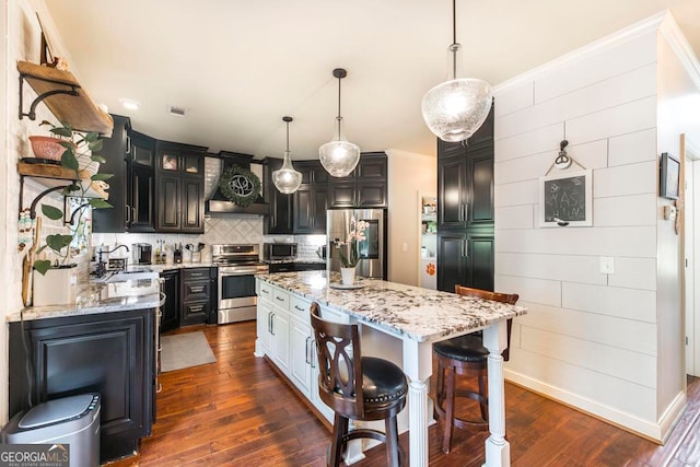 kitchen featuring a kitchen island, stainless steel appliances, pendant lighting, custom range hood, and dark hardwood / wood-style floors