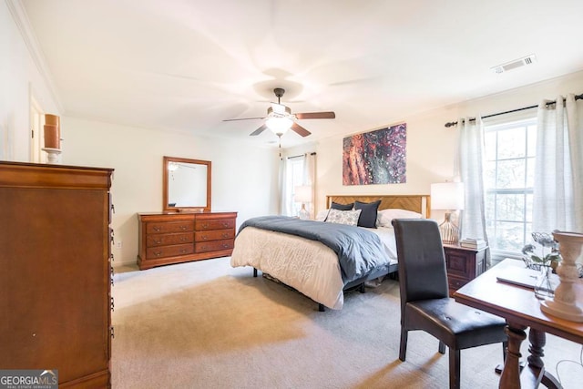 bedroom with crown molding, light carpet, and ceiling fan