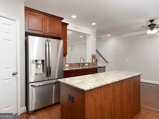 kitchen featuring dark wood-type flooring, sink, appliances with stainless steel finishes, ornamental molding, and ceiling fan