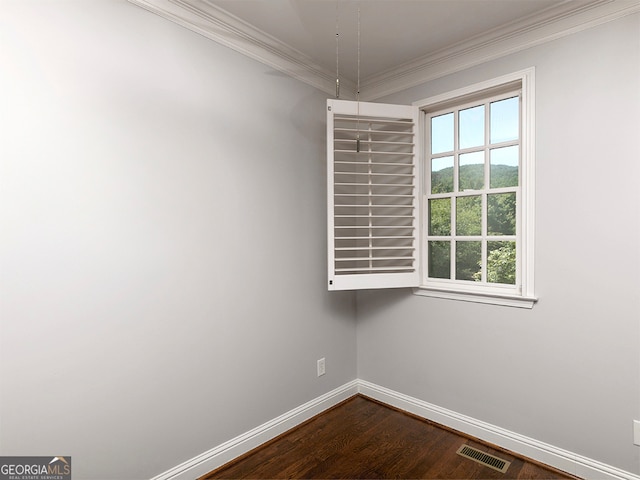 empty room with hardwood / wood-style flooring and crown molding