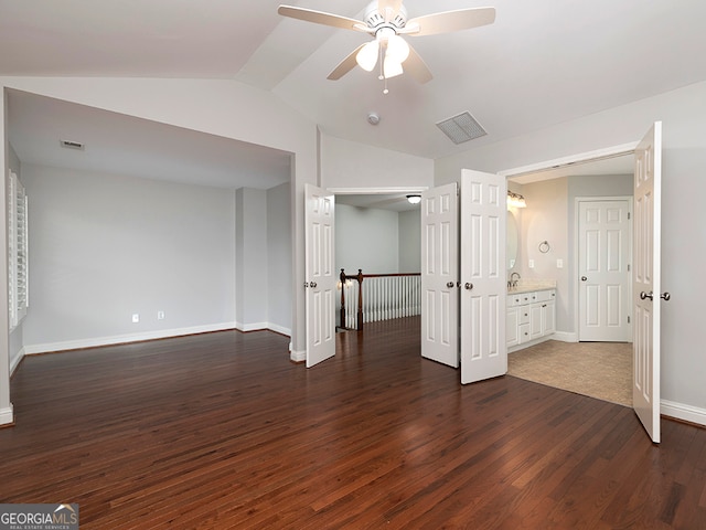 unfurnished bedroom with ensuite bath, ceiling fan, vaulted ceiling, and dark hardwood / wood-style floors