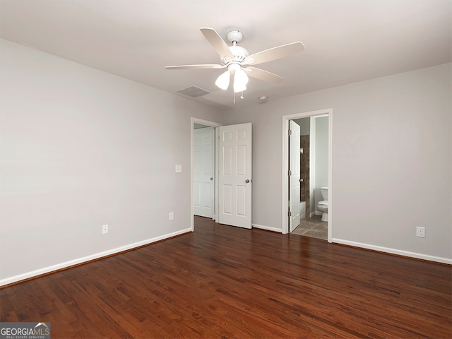 unfurnished bedroom featuring connected bathroom, dark hardwood / wood-style flooring, and ceiling fan