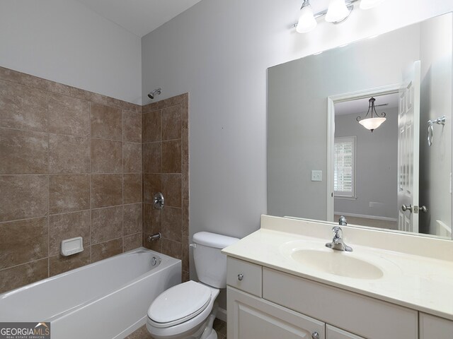 full bathroom with vanity, tiled shower / bath combo, and toilet