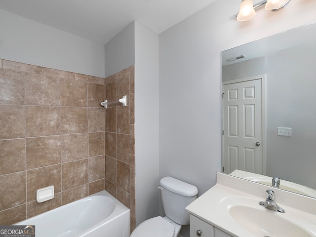 full bathroom featuring tiled shower / bath combo, vanity, and toilet