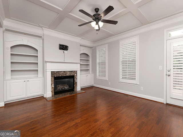 unfurnished living room with ceiling fan, built in features, a premium fireplace, coffered ceiling, and dark hardwood / wood-style floors