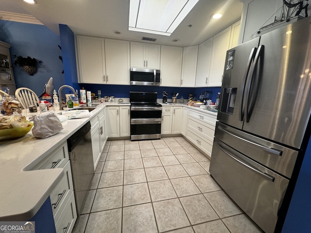 kitchen featuring light tile patterned floors, stainless steel appliances, a sink, visible vents, and light countertops