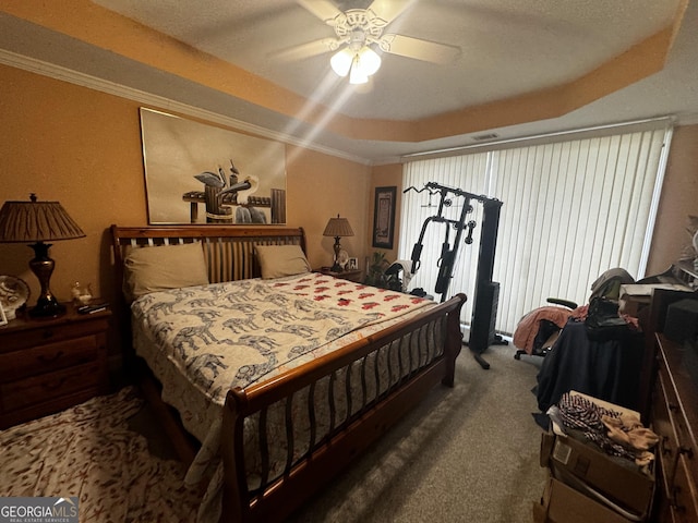 bedroom featuring carpet floors, a raised ceiling, crown molding, and a ceiling fan