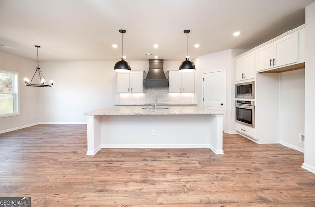 kitchen with dark wood-type flooring, white cabinets, sink, appliances with stainless steel finishes, and light stone counters