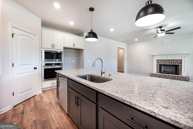 kitchen featuring white cabinets, premium range hood, sink, and hardwood / wood-style floors