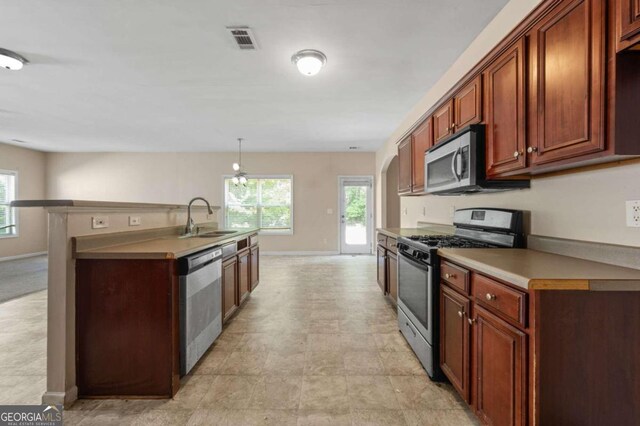 kitchen with sink, light tile patterned flooring, pendant lighting, and stainless steel appliances