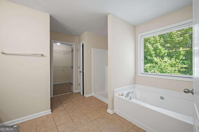 bathroom featuring a wealth of natural light, plus walk in shower, and tile patterned floors