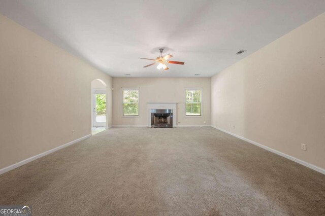 unfurnished living room featuring carpet floors and ceiling fan