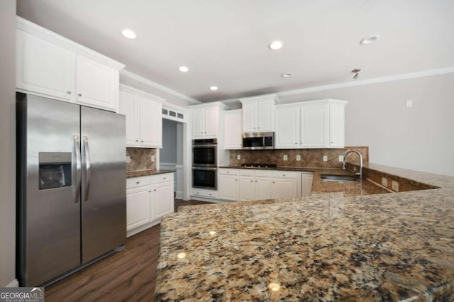 kitchen featuring appliances with stainless steel finishes, decorative backsplash, dark hardwood / wood-style floors, sink, and white cabinets