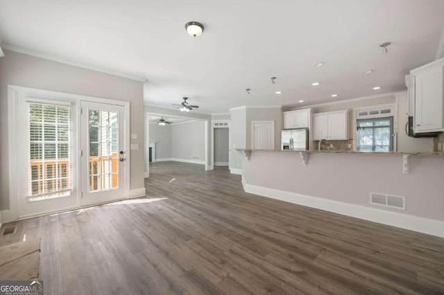 unfurnished living room featuring dark hardwood / wood-style flooring, a wealth of natural light, and ceiling fan