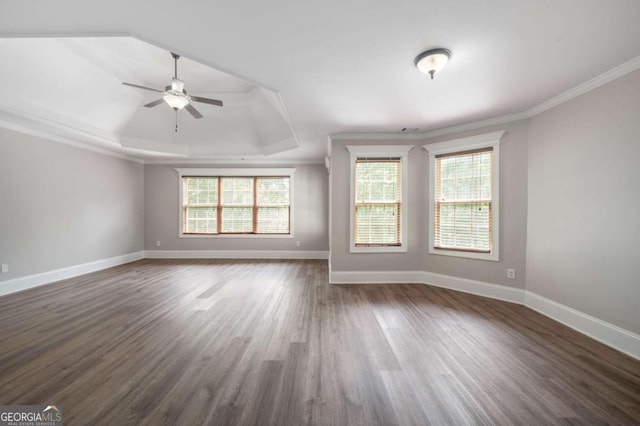 empty room featuring ceiling fan, a raised ceiling, crown molding, and dark hardwood / wood-style floors