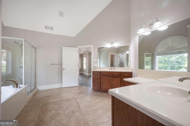 bathroom featuring tile patterned flooring, separate shower and tub, high vaulted ceiling, and vanity