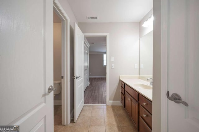 bathroom featuring tile patterned flooring, vanity, and toilet