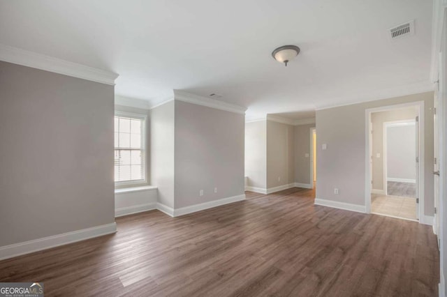 empty room featuring ornamental molding and wood-type flooring