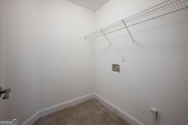 washroom with dark tile patterned flooring and washer hookup