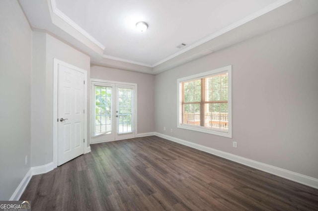 empty room featuring dark hardwood / wood-style flooring, plenty of natural light, and ornamental molding