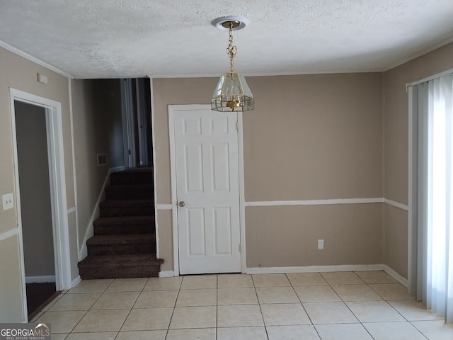 interior space with a textured ceiling, a chandelier, and light tile patterned flooring