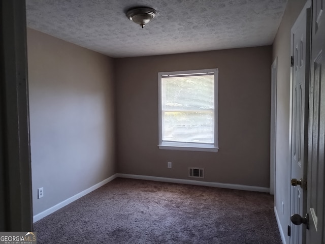 carpeted spare room with a textured ceiling