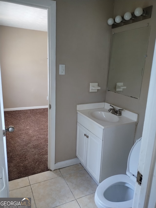 bathroom featuring tile patterned flooring, toilet, and vanity