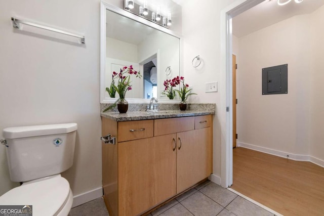 bathroom with electric panel, toilet, tile patterned floors, and vanity