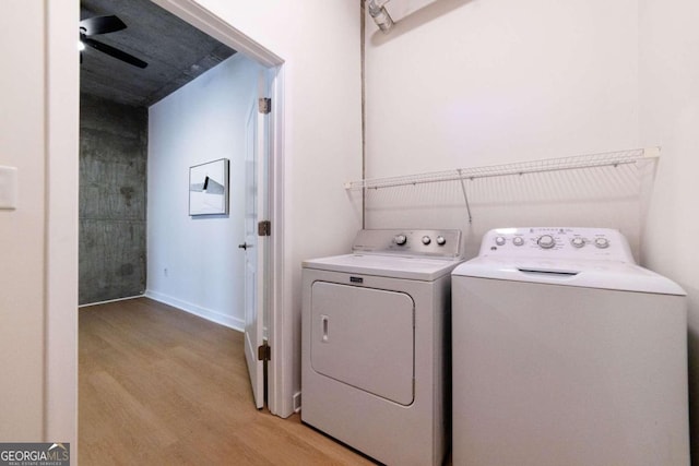 laundry room with independent washer and dryer and light hardwood / wood-style floors