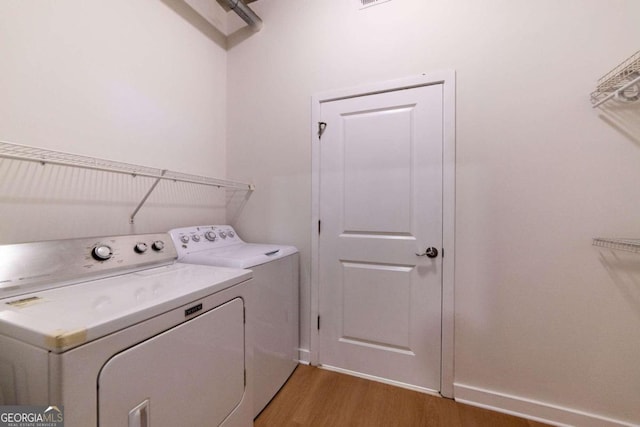 laundry area featuring light hardwood / wood-style floors and washing machine and dryer