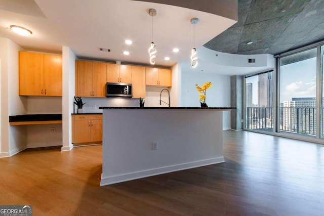 kitchen with decorative backsplash, expansive windows, pendant lighting, and wood-type flooring