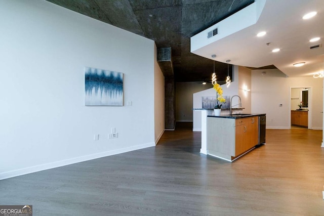 kitchen featuring sink, hanging light fixtures, dishwasher, and wood-type flooring