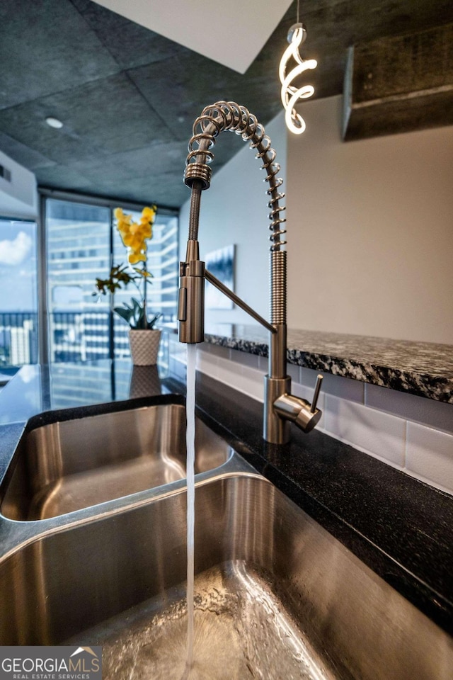 interior details featuring dark stone countertops and a notable chandelier