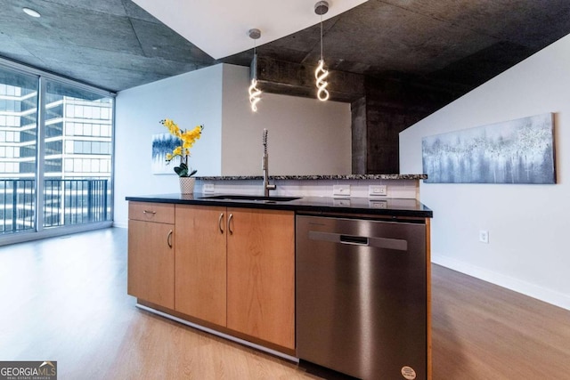 kitchen featuring sink, light wood-type flooring, stainless steel dishwasher, and floor to ceiling windows