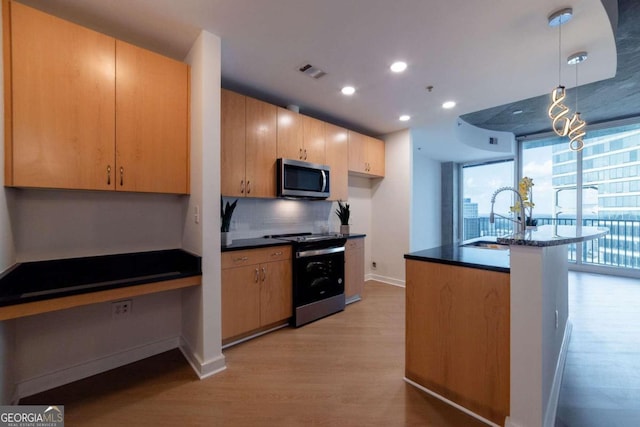 kitchen featuring sink, light hardwood / wood-style flooring, decorative backsplash, stainless steel appliances, and pendant lighting