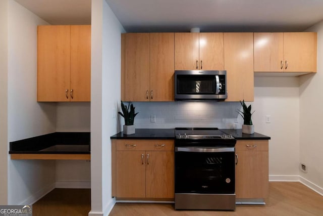 kitchen featuring decorative backsplash, light hardwood / wood-style flooring, and appliances with stainless steel finishes