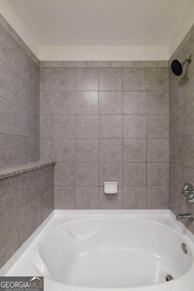 bathroom featuring tiled shower / bath