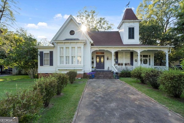 victorian home featuring covered porch and a front lawn