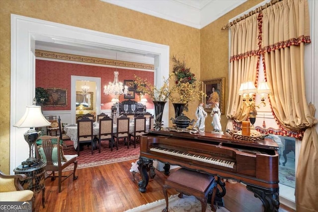 misc room with hardwood / wood-style floors, crown molding, and a chandelier