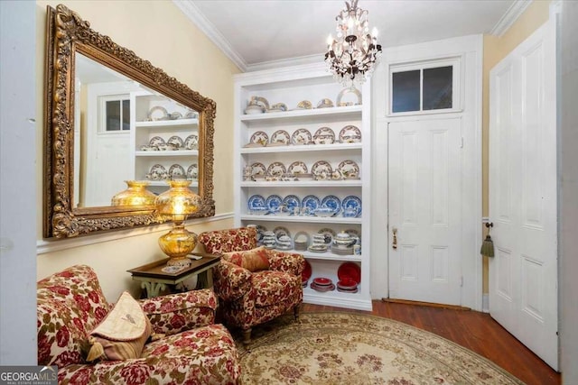 sitting room featuring hardwood / wood-style floors, an inviting chandelier, and ornamental molding