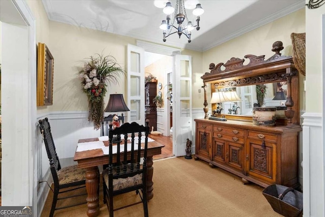 carpeted dining space featuring a chandelier and ornamental molding