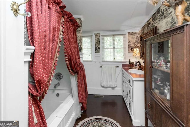 bathroom with wood-type flooring, ornamental molding, and vanity