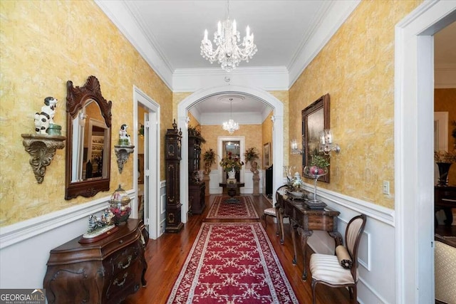 hall with hardwood / wood-style flooring, an inviting chandelier, and ornamental molding