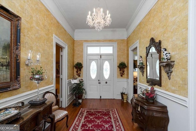 entrance foyer with hardwood / wood-style flooring, crown molding, and an inviting chandelier