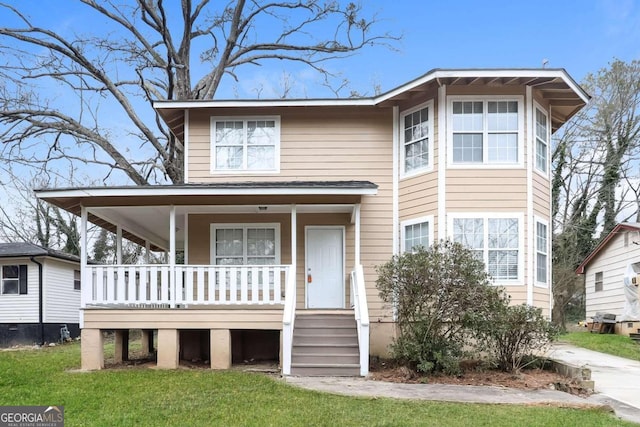 view of front of house with covered porch and a front lawn