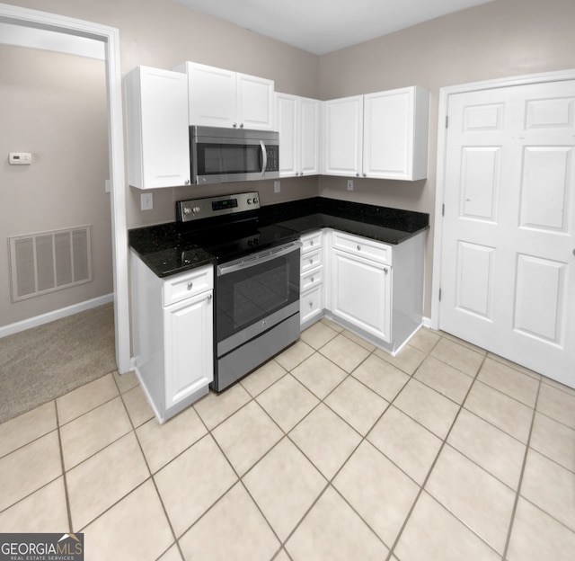 kitchen featuring light carpet, appliances with stainless steel finishes, and white cabinetry