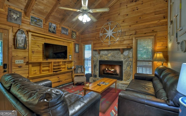 living room featuring a fireplace, beamed ceiling, wooden walls, ceiling fan, and wooden ceiling