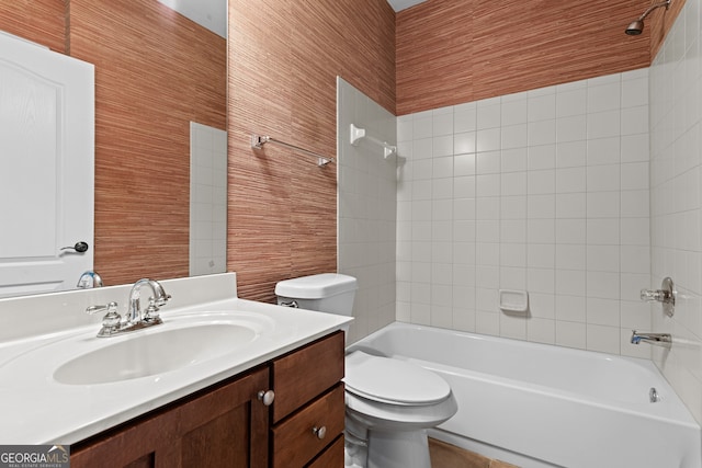 full bathroom featuring tiled shower / bath combo, vanity, and toilet