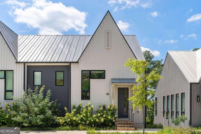 modern inspired farmhouse with board and batten siding, metal roof, and a standing seam roof